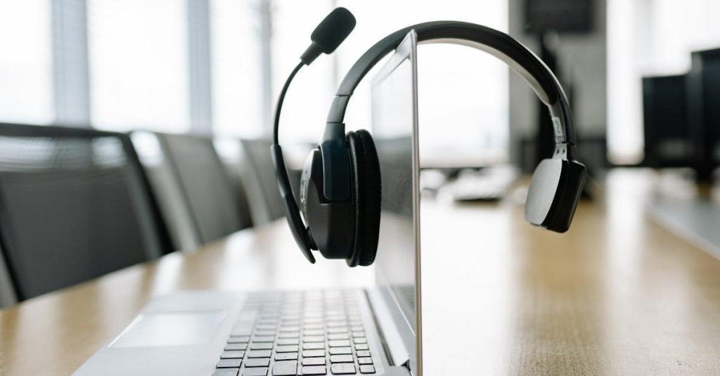 Sleek laptop with a wireless headset in a bright, modern office setting.